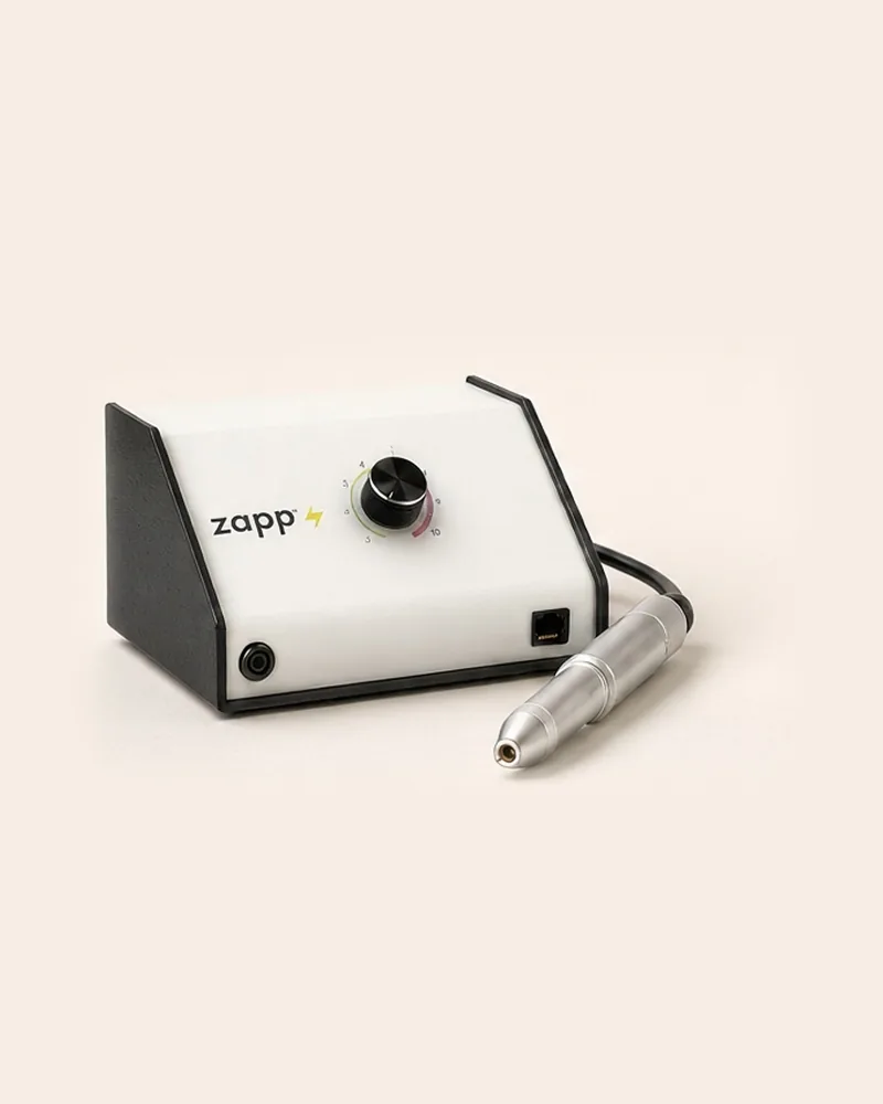 Soldadora Sunstone Zapp para joyería permanente con su estilete, sobre un fondo crema.