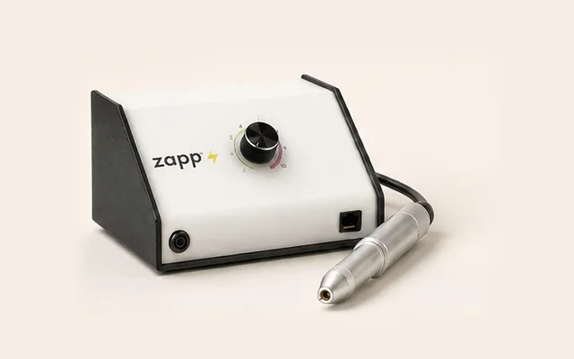 Soldadora Sunstone Zapp para joyería permanente con su estilete, vista de producto sobre fondo crema.